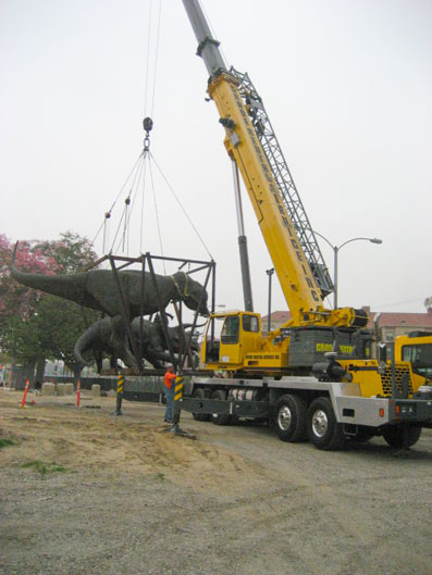 Dueling Dinos aloft, enroute to their new digs.